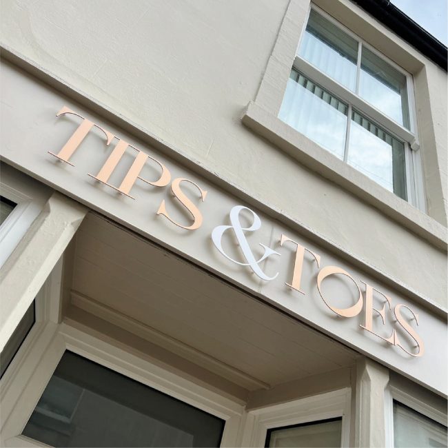 Exterior timber sign fascia with copper and white letters on stand-fixings to create shadows on sunny days